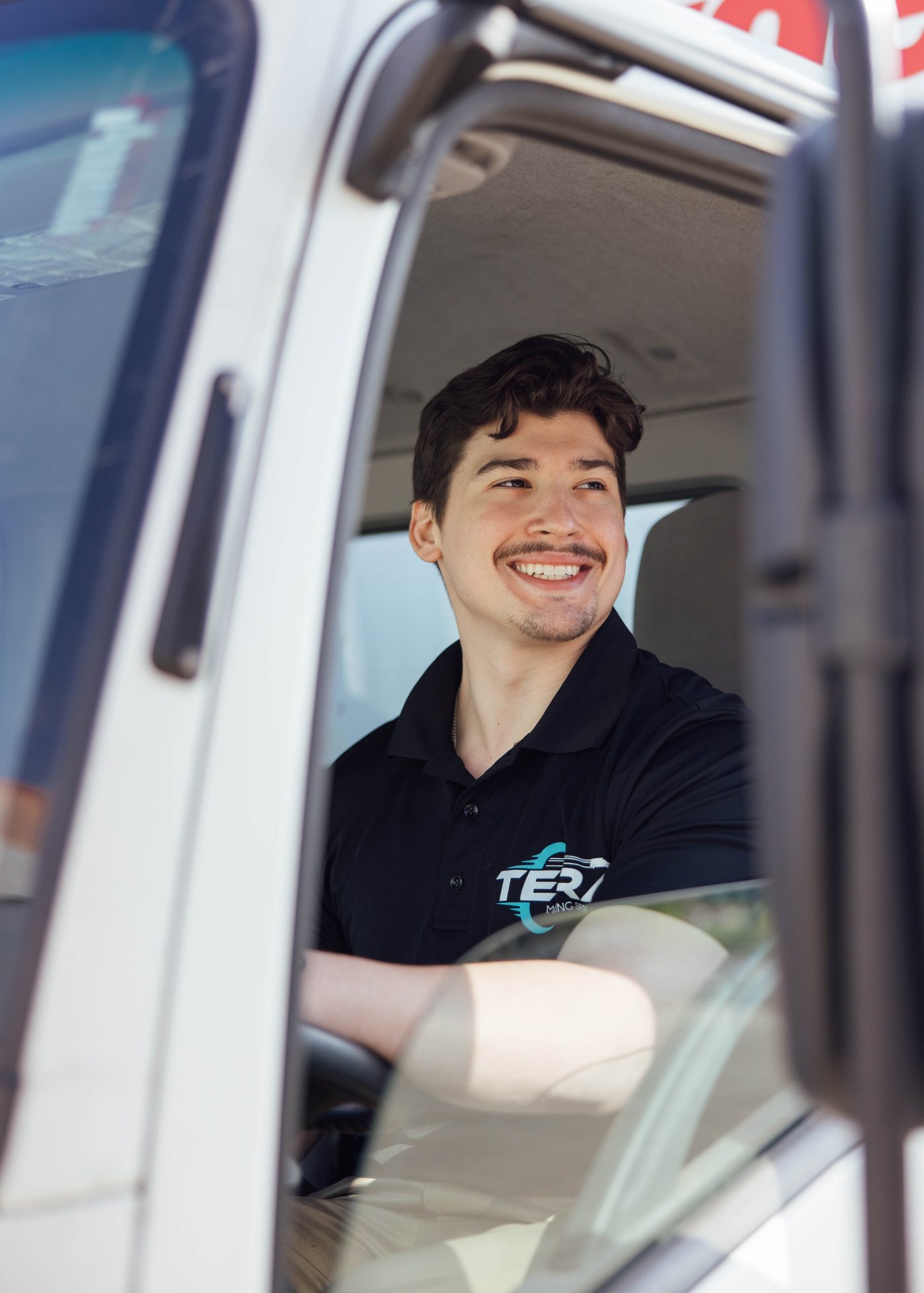 A Tera Moving driver behind the wheel of a loaded moving truck in Houston