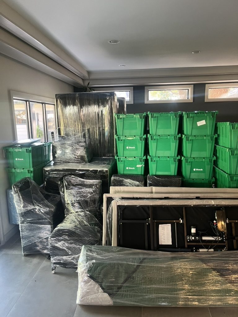 Stack bins and professionally wrapped furniture staged for a Tera local move in a Houston home