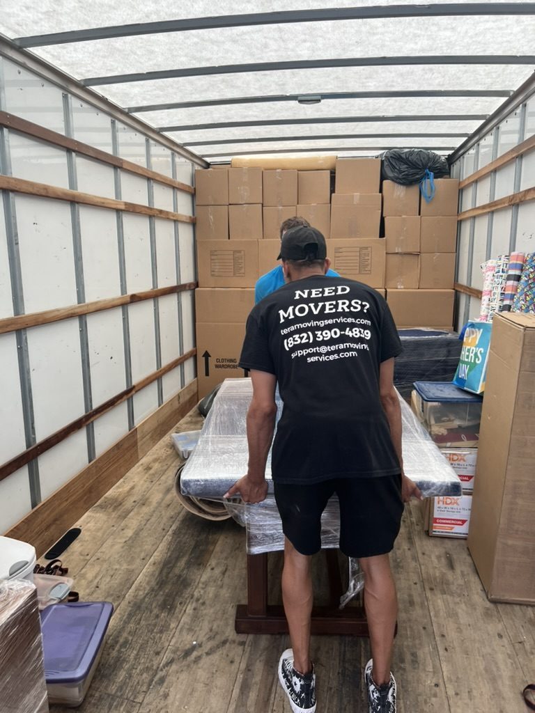 Tera Moving crew member loading a wrapped piece into a fully packed truck for a long-distance move